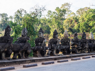 The lining of guardian  protecting the front gate of the ancient castle of Angor Thom city at Angor Wat area. This guards have many faces and holding the long stick, looks so strong and powerful