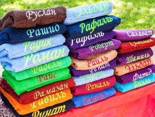 Stack of the multicolored towels with embroidered Tatar names