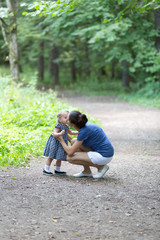 Mom and daughter are walking through the woods