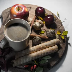 Foto op Plexiglas autumn coffe drink with waffers, apple and cinnamon and autumn leaves on wooden plank against white background © Magdalena