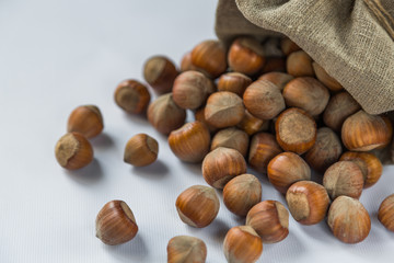 hazelnut on a white wooden background in a bag