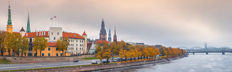 Obraz premium Waterfront of Daugava river and medieval part of old Riga at misty morning. Riga is the capital of Latvia and famous tourist site in Baltic region of Europe