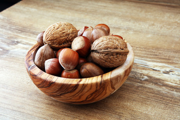 Large diversity of healthy nuts in wooden bowl.