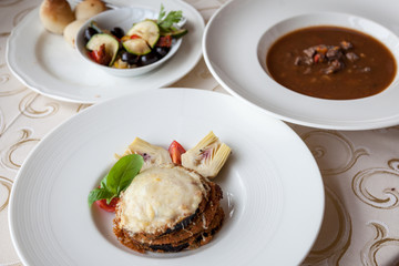 Breaded eggplant with tomato pesto, mozzarella and parmesan cheese with artichokes and Wild boar goulash soup