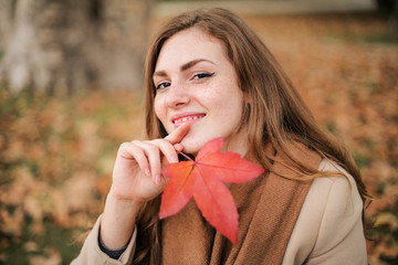 Beautiful smiling girl portrayed in an autumn day