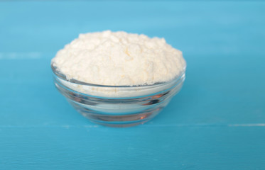 flour in a cup on a blue background