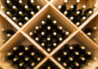 stacked bottles of grape wine in a wine cellar