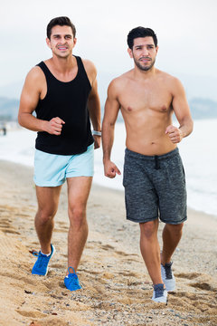Two sportsmen jogging on beach