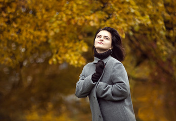 Beautiful elegant woman in autumn park. Fall yellow garden background