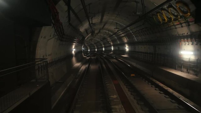 View of a subway tunnel as seen from rear window of a moving train. Underground train arriving modern subway station. long footage of an underground train in Barcelona following its route. 4k