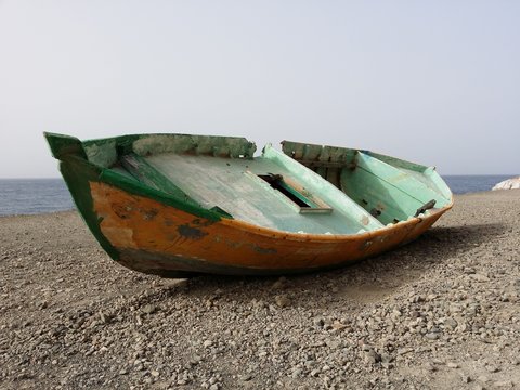 altes Fischerboot grün orange auf dem Strand