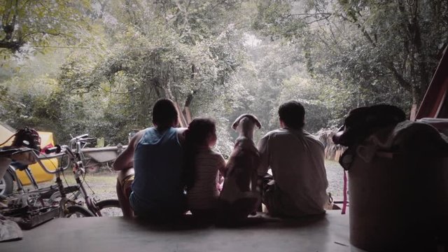 Silhouette of family seated on the porch of the house