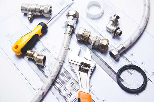 A selection of plumbing tools and fittings on domestic house plans