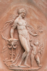Fototapeta na wymiar Terracotta half-relief, nude woman and boy, in Impruneta, Italy