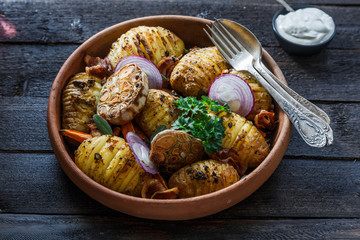 Oven-baked hassleback potatoes with onion and bacon