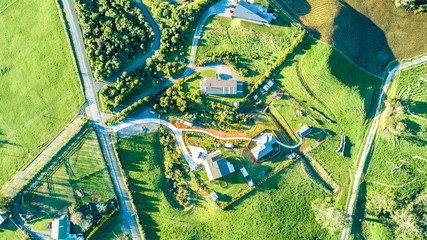 Aerial view on a farmland with roads and small houses. Taranaki region, New Zealand