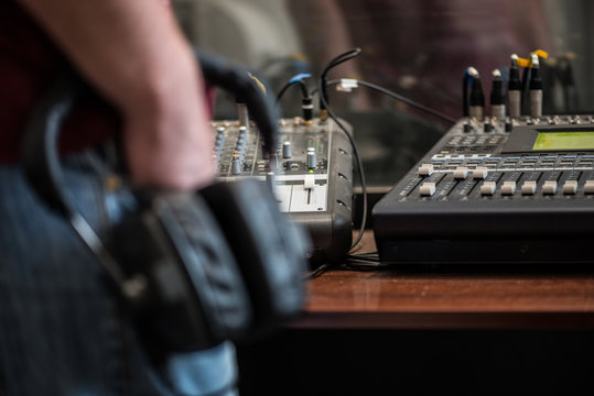 silhouette of a man holding headphones in radio studios