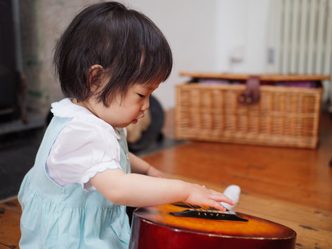 Baby Girl Play Guitar At Home