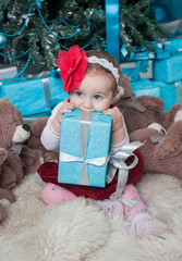 Little girl near Christmas tree with gifts
