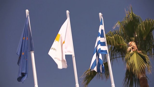 Flags of the European Union, Greece, Cyprus, the city of Aya Napa, Greece, Flags on the flagpole, the wind waving the flag, Flags on flagpole, wind waving flag, against blue sky background