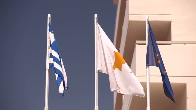 Flags of the European Union, Greece, Cyprus, the city of Aya Napa, Greece, Flags on the flagpole, the wind waving the flag, Flags on flagpole, wind waving flag, against blue sky background