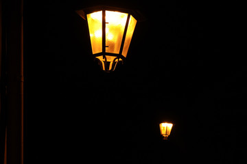 Torches breaking the darkness. Two torches are lighting the street during a pitch-dark night.