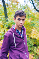 Portrait of a serious teenage boy in an autumn forest