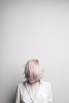 Pink-haired girl with covered face.