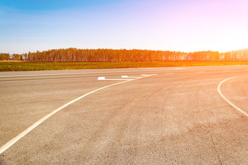 The picturesque landscape and the Sunrise over the road. Asphalt road with marking. With the blur...