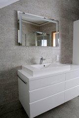 Furnished bathroom with white furniture, tiles in grey