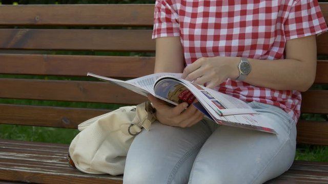 Woman Reading Magazine In The Park