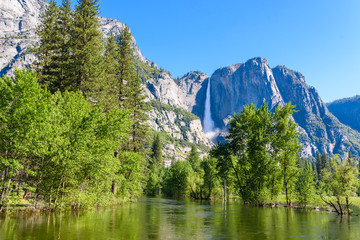 Fototapeta premium Yosemite National Park - Reflection in Merced River of Yosemite waterfall and beautiful mountain landscape, California, USA