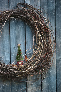 Old Wreath With Small Tree Ornament On Barn Wall