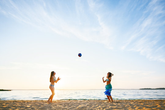 Young women playing beach ball on the beach