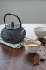 Image of traditional eastern teapot and teacups on wooden desk 