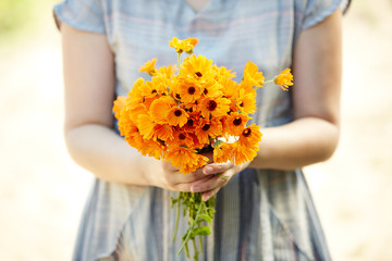 Woman holding calendula flowers for aromatherapy