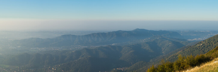 Fototapeta premium Morning landscape on the Padana plain with high pollution and humidity in the air. Panorama from Linzone Mountain, Bergamo, Italy