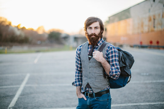 Portrait of a hip and trendy bearded man in a parking lot