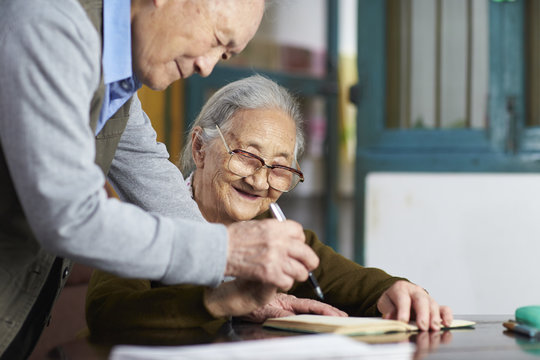 senior asian couple writing