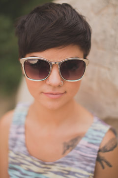 Closeup of short haired edgy girl wearing sunglasses