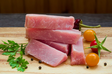 Meat pork slices on a wooden table closeup, 