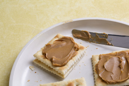 Dish with saltine crackers and peanut butter