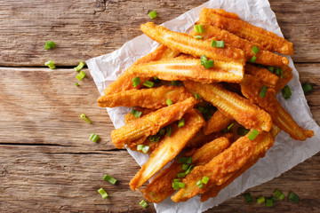 Delicious snack of fried baby corn close-up on the table. horizontal top view © FomaA