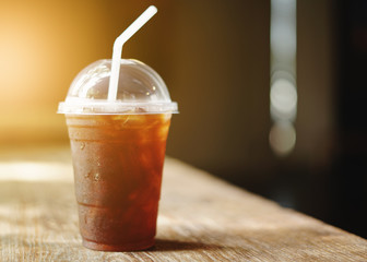 Cold iced black coffee on wooden table background.