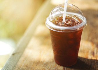 Cold iced black coffee on wooden table background.