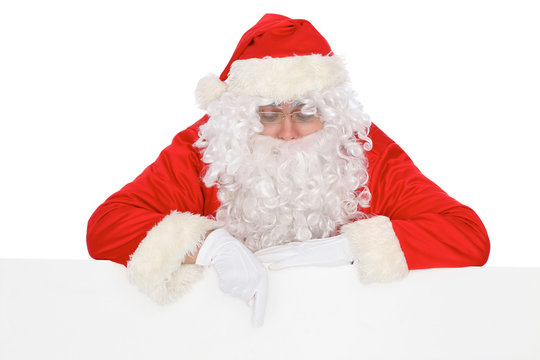 Santa Claus pointing on blank white wall, advertisement banner with copy space. Isolated on white background