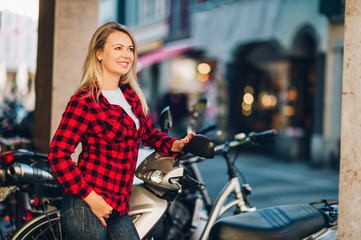 Fototapeta na wymiar Outdoor portrait of beautiful blond woman wearing red plaid shirt
