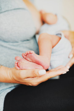 Close up image of baby's feet holding by a mother