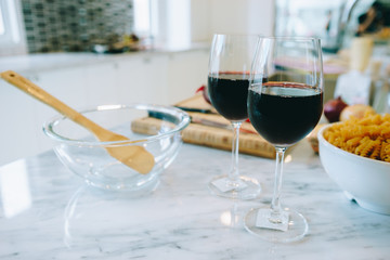 2 glasses of wine placed on the table in the kitchen in a beautiful home.