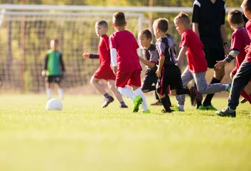 Rolgordijnen Kids soccer football - children players match on soccer field © Dusan Kostic